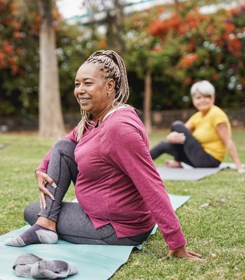 People doing exercises outside on mats